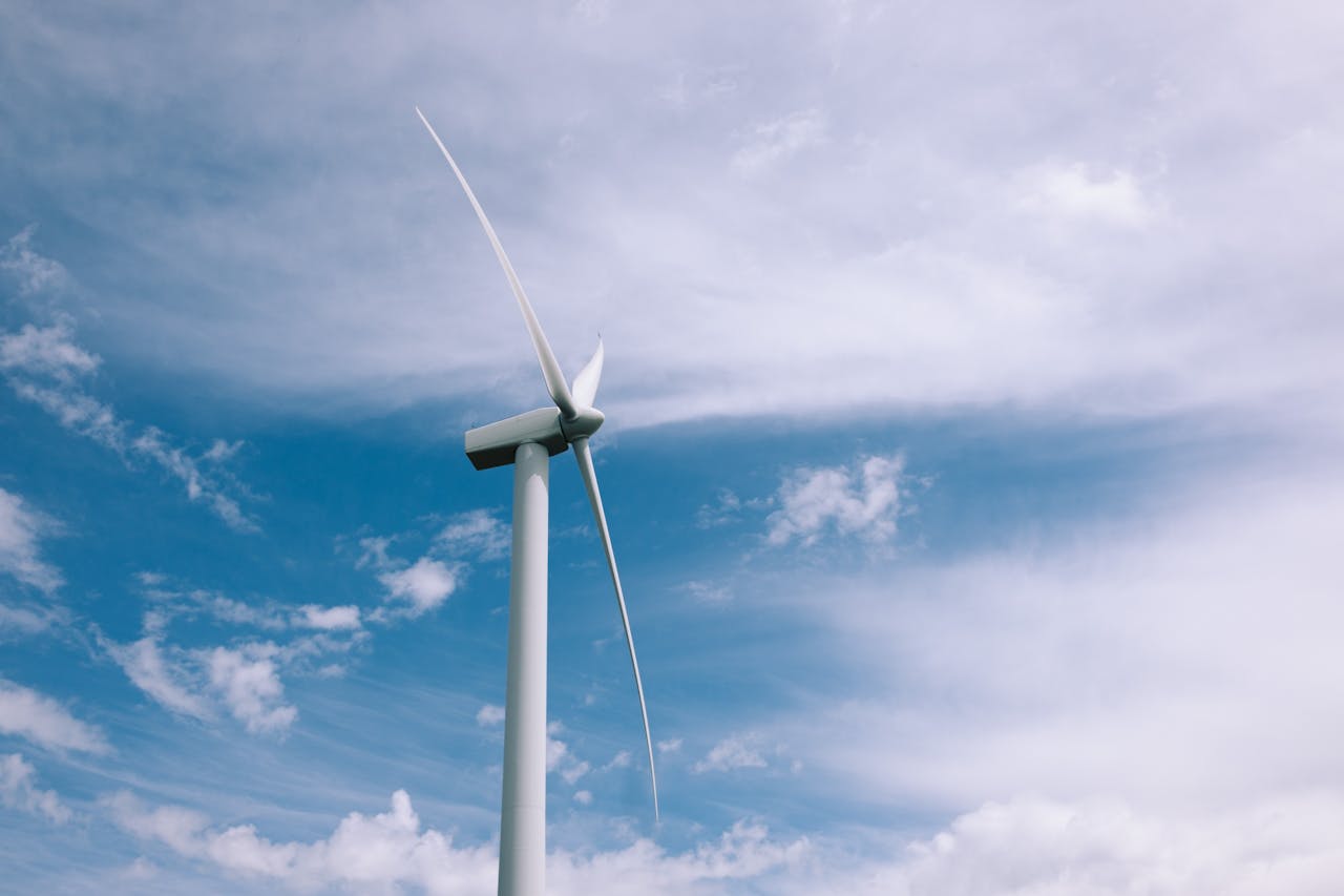 A wind turbine spinning beneath a clear blue sky, symbolizing renewable energy.